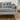 Close-up of a mid-century grey tweed sofa featuring button-tufting and a cylindrical bolster pillow by Black Label Home
