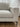 Detail of the Blake sectional's light gray upholstered arm and slender leg