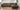Hector sofa with a chaise in brown upholstery and a continuous plinth base