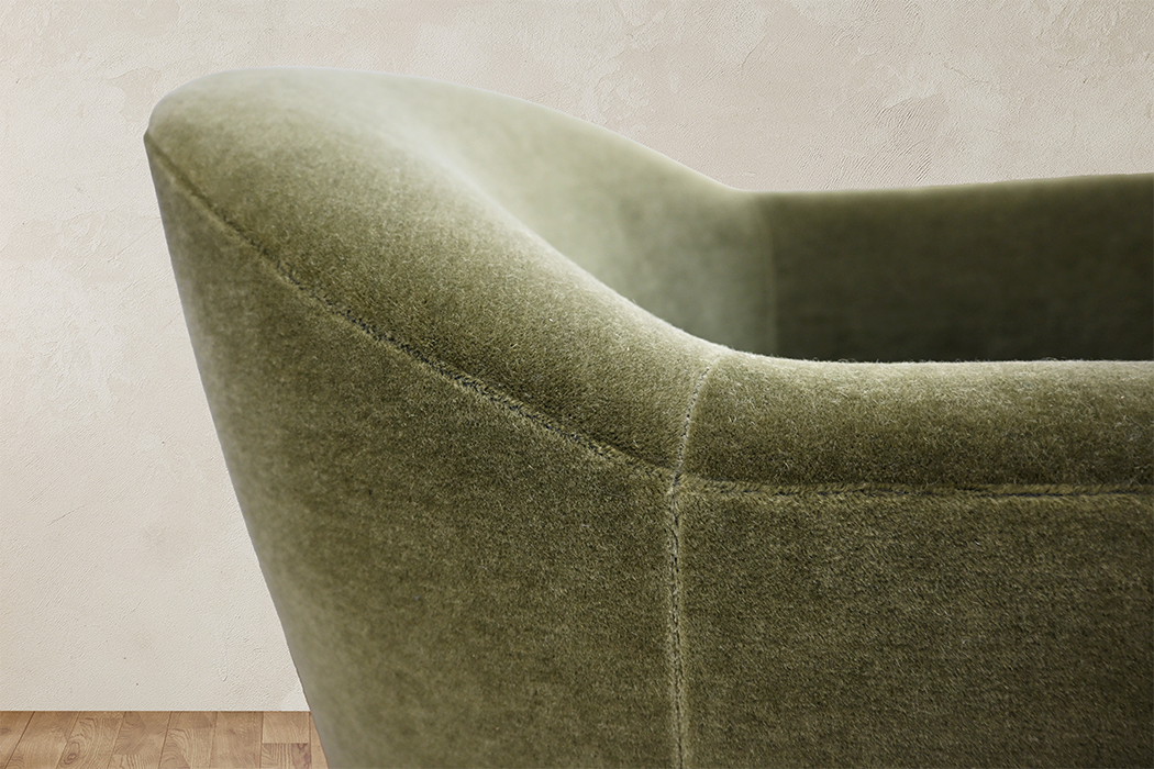 Close-up of the olive upholstery and curved back of the Dimitri chair